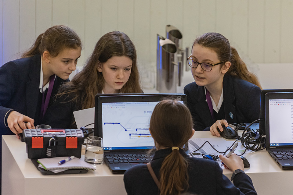 A photograph of school children sitting at desks learning about cyber security